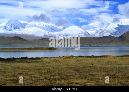 Lago Karakul e snowcovered mountains nello Xinjiang, Karakorum highway, Cina Foto Stock