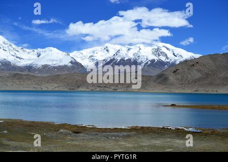 Lago Karakul e snowcovered mountains nello Xinjiang, Karakorum highway, Cina Foto Stock