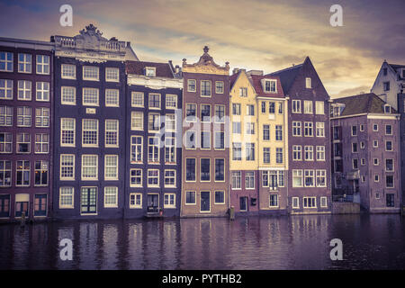 Look retrò colorato canal tradizionali case sul lungomare su Damrak nel Patrimonio mondiale dell UNESCO di Amsterdam Foto Stock