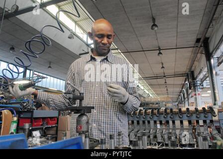 Il Tuareg comunità di immigrati a Pordenone, Italia nord-orientale; Mohamed Abety al suo posto di lavoro in un macchinario tessile factory Foto Stock