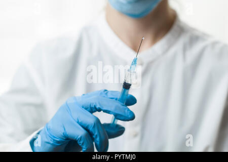 Il dottore iniettato il vaccino con una siringa. Foto Stock