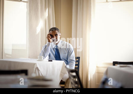 Preoccupato per il businessman seduta sul suo proprio nel ristorante. Foto Stock
