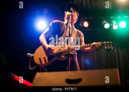 Ragazzo adolescente suonando una chitarra elettrica sul palco. Foto Stock