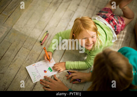 Sorridente ragazza di colorazione con sua madre. Foto Stock