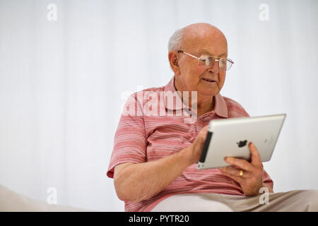 Senior uomo guardando una tavoletta digitale. Foto Stock