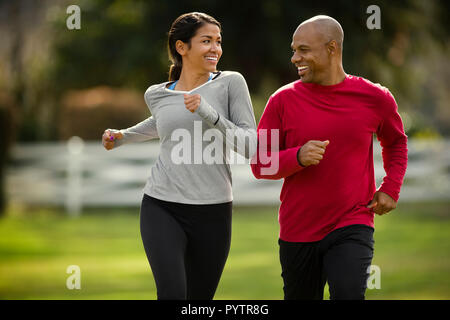 Felice coppia giovane andare a correre insieme al parco. Foto Stock