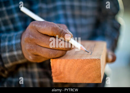 Builder il taglio di un pezzo di legno con una sega circolare. Foto Stock