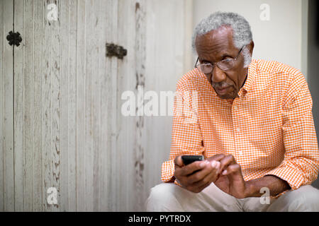 Il vecchio uomo tramite telefono cellulare Foto Stock