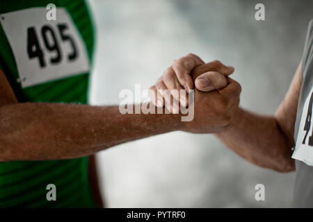 Le braccia e le mani di due alti uomini di wrestling. Foto Stock