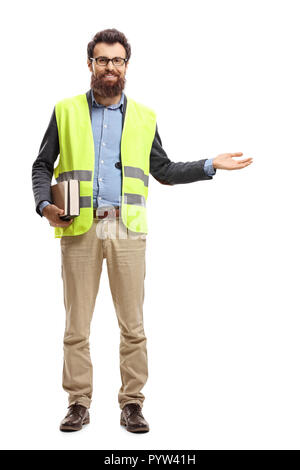 A piena lunghezza Ritratto di un uomo barbuto con libri, indossare un giubbotto di sicurezza e gesticolando benvenuto con mano isolati su sfondo bianco Foto Stock