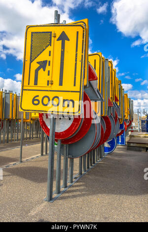 Giallo su strada segno di restringimento tra le altre righe della segnaletica stradale in attesa di essere ingaggiato in progetti di costruzione stradale Foto Stock