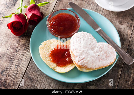 Il giorno di San Valentino la prima colazione con caffè, a forma di cuore bun e marmellata di frutti di bosco. Foto Stock