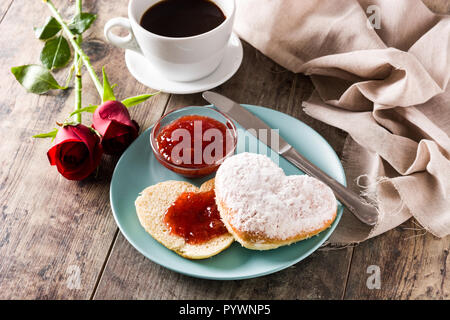 Il giorno di San Valentino la prima colazione con caffè, a forma di cuore bun e marmellata di frutti di bosco. Foto Stock
