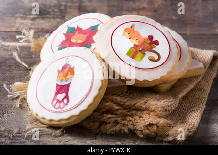 Biscotti di Natale decorato con la grafica di Natale, su un tavolo di legno. Foto Stock