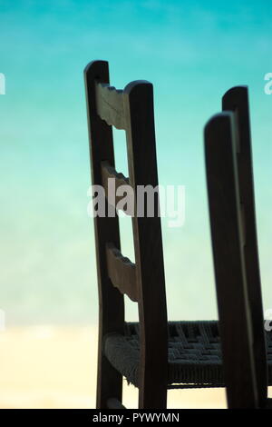 Primo piano dettaglio di tradizionali sedie in legno - vimini, presso una taverna sulla spiaggia sulla splendida isola greca di Koufonissi. Sfondo bokeh – spazio di copia. Foto Stock