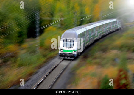 Treni passeggeri ad una velocità in autunno, vista in elevazione, motion blur. Foto Stock