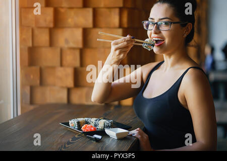 Ragazza a mangiare il sushi al ristorante Foto Stock