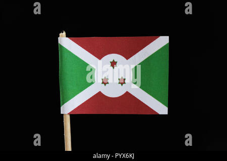 Una bandiera ufficiale del Burundi su stuzzicadenti su sfondo nero. È costituito da quattro verde e triangolo rosso con tre stelle rosse in medio in bianco cir Foto Stock