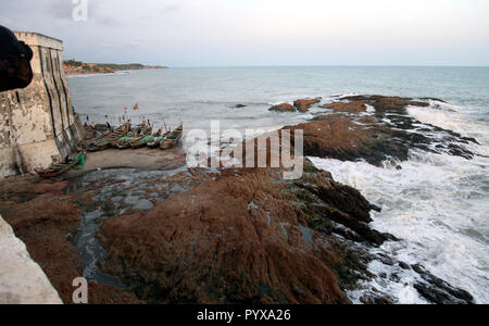 I pescatori e barche da pesca alla base di Cape Coast Castle a Cape Coast, in Ghana Foto Stock