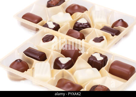 Assortimento di cioccolatini in scatole di plastica su sfondo bianco. Foto Stock