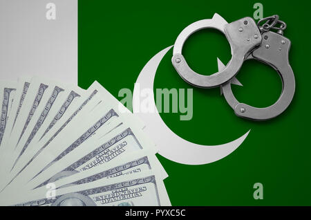 Il Pakistan bandiera con le manette e un fascio di dollari. Il concetto di illegale delle operazioni bancarie in valuta statunitense. Foto Stock