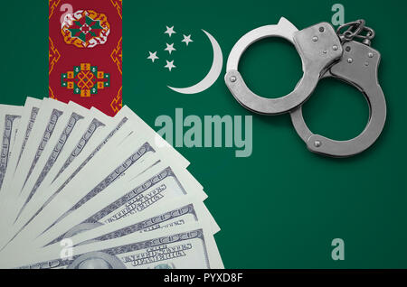 Turkmenistan bandiera con le manette e un fascio di dollari. Il concetto di illegale delle operazioni bancarie in valuta statunitense. Foto Stock