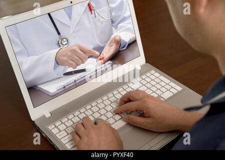 Un uomo di mezza età che utilizza la telemedicina per ascoltare un medico per il farmaco. Foto Stock