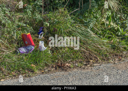 Tratto di corsia di campagna disseminata di lettiere. Lettiera stradale Concept UK. Tenere la Gran Bretagna in ordine, rifiuti di plastica su strada. Per la campagna Clean Up Britain. Foto Stock