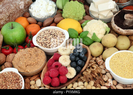 Della salute alimentare per i vegani con grani, mandorla di burro e yogurt, tofu tofu, noci, frutta, verdura, pane integrale. Foto Stock