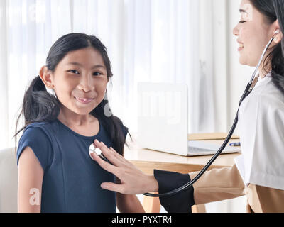 Medico di esaminare una bambina da uno stetoscopio Foto Stock