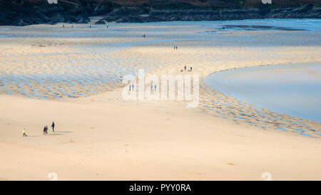 Persone visto da una distanza a piedi su Crantock Beach in Newquay in Cornovaglia. Foto Stock