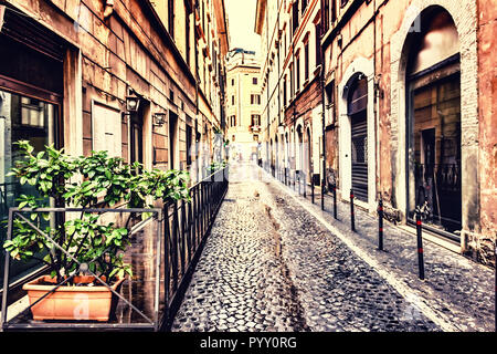 Stretta strada italiano con un caffè accogliente terrazza in una zona alla moda di Roma Foto Stock