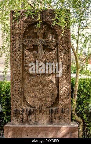 Medievale croce di pietra sotto l'albero di salice nel giardino della chiesa di San Mesrop Mashtots nel villaggio di Oshakan Foto Stock