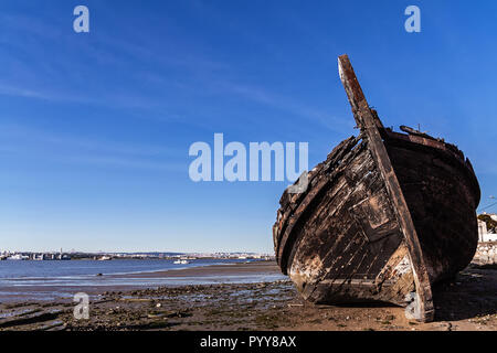 Tradizionale vecchio fiume Tago imbarcazioni a vela di legno bruciato e distrutto nella baia di Seixal, Portogallo Foto Stock