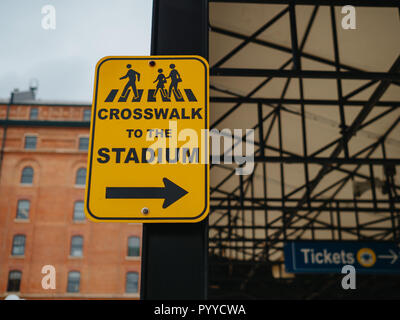 Crosswalk giallo allo stadio segno rivolta verso destra in prossimità di un ballpark Foto Stock