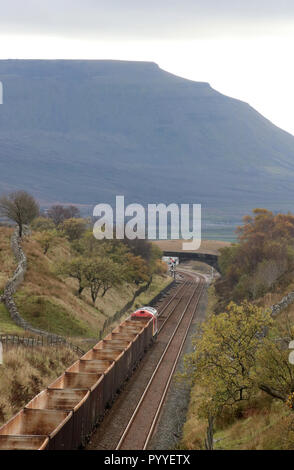 Diesel-elettrico loco alaggio rastrello di carri vuoti a stabilirsi a Carlisle linea ferroviaria tra Blea Moor tunnel e la casella segnale, Ingleborough in distanza Foto Stock