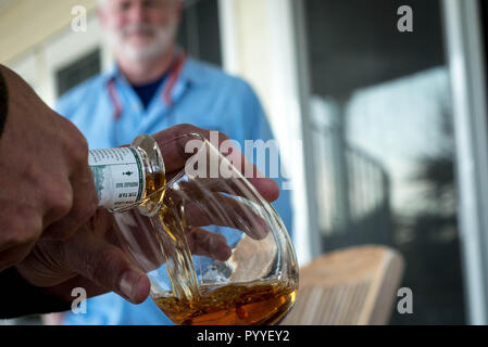 Un uomo condivide il whisky con gli amici. Foto Stock