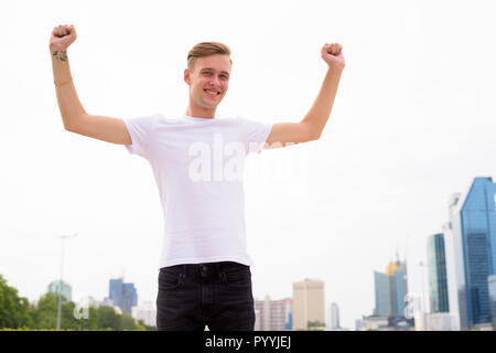 Giovane uomo bello con capelli biondi di relax presso il parco Foto Stock