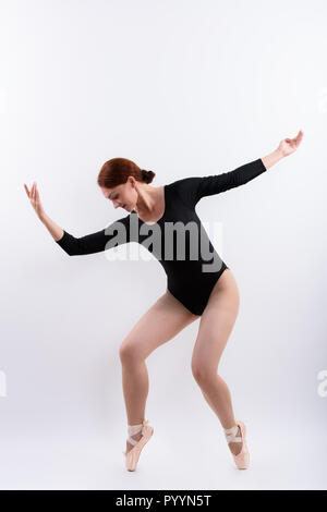 Corpo pieno colpo di donna ballerina in posa sulle dita dei piedi Foto Stock