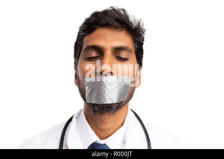 Indian medic tacitato con bocca essendo fissato con nastro adesivo come non dire segreto professionale isolato su bianco Foto Stock