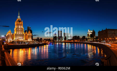 Vista aerea di alberghi con fiume e grattacieli di Mosca, Russia. Tramonto sulla città. Cielo blu chiaro Foto Stock