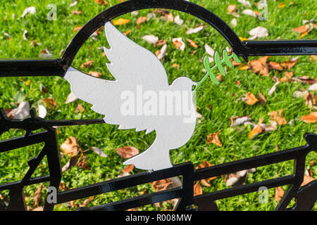 Simbolo di pace, una colomba bianca con ramo di alloro realizzata in metallo sul retro del banco Temple Gardens Llandrindod Wells Powys Wales UK. Foto Stock