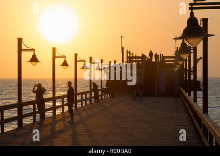 La Namibia tramonto - i turisti sul pontile, Swakopmund, Namibia Africa Foto Stock