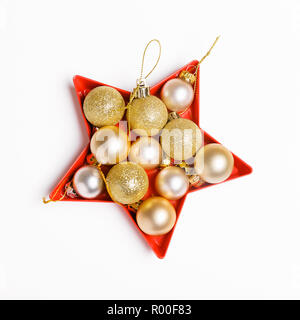 Vacanze di Natale composizione. Festa di Natale palline dorate stabiliti nella forma di una stella su uno sfondo bianco. Foto Stock