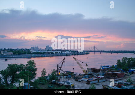 Una bella rosa tramonto sopra il fiume della città. Paesaggio industriale Foto Stock