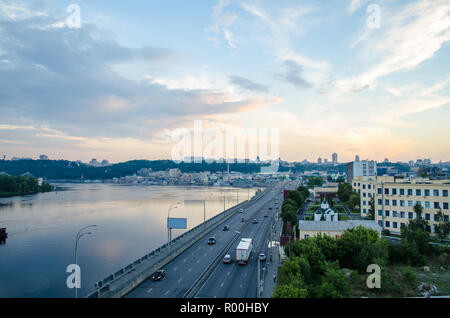 Un bel tramonto sulla città. Paesaggio industriale con il fiume della città e la vista del centro della città Foto Stock