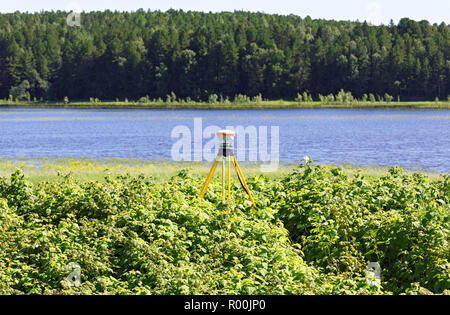 Geodetiche ricevitore GNSS nel campo in Siberia, montato su un treppiede vecchio. Applicazione pratica per il funzionamento in reti permanenti di stazioni di base Foto Stock