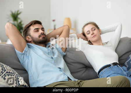 Moglie e marito di mettere le mani dietro la testa di appoggio giacente Foto Stock