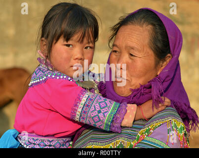 Anziani fiore vietnamita H'mongs minoranza etnica donna con il suo piccolo nipote. Foto Stock