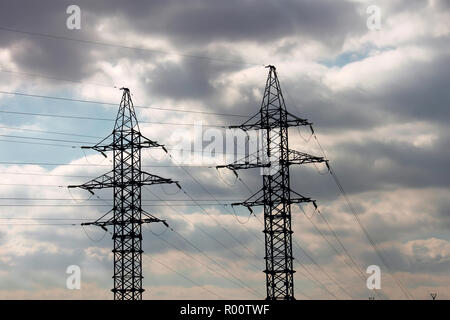 I due pilastri elettrico sullo sfondo del cielo molto nuvoloso Foto Stock